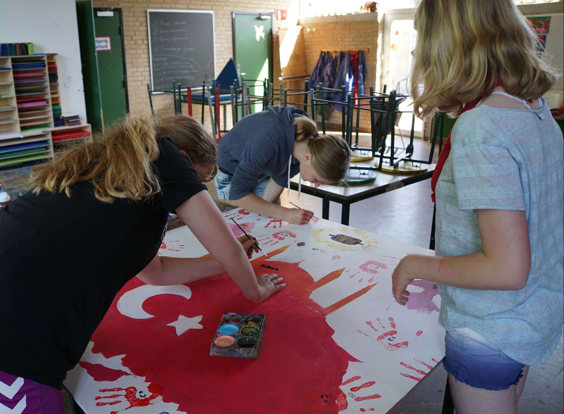 Tre piger maler i billedkunstlokalet